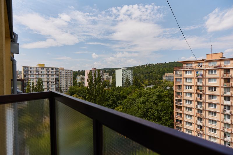PREDAJ,3-IZBOVÝ BYT,KOMPLETNÁ REKONŠTRUKCIA,BOŽENY NEMCOVEJ-SEVER-KE - Výhľad z balkóna s panelákmi a stromami na ulici Boženy Němcovej v Košiciach.