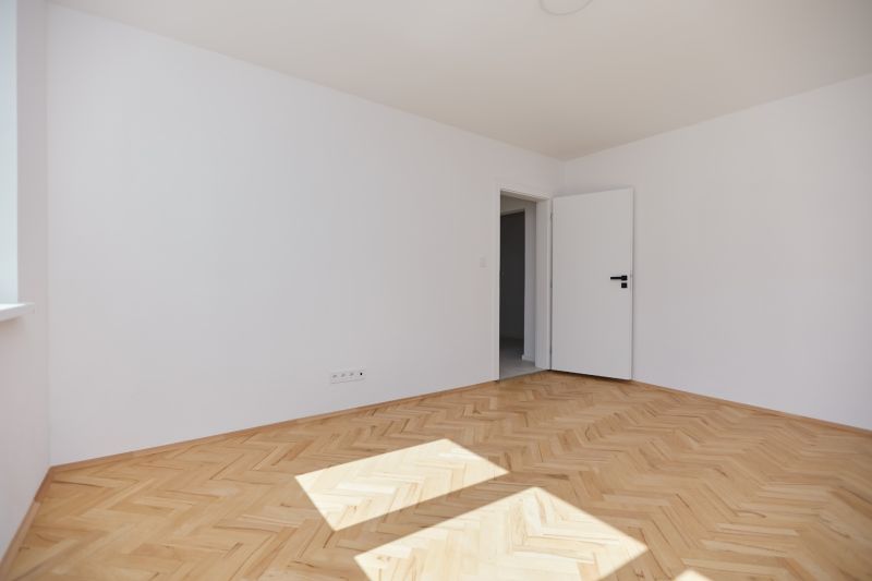NA PREDAJ-3-IZBOVÝ BYT-NOVÁ REKONŠTRUKCIA-UL.POKROKU-KOŠICE-ZÁPAD - Svetlá miestnosť s bielymi stenami a podlahou s dreveným dekorom, 3-izbový byt.