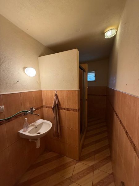 DOM NA PREDAJ, Obec Sikenica, okres Levice - Kúpeľňa v rodinnom dome s podlahou s dreveným dekorom a sprchovým kútom.