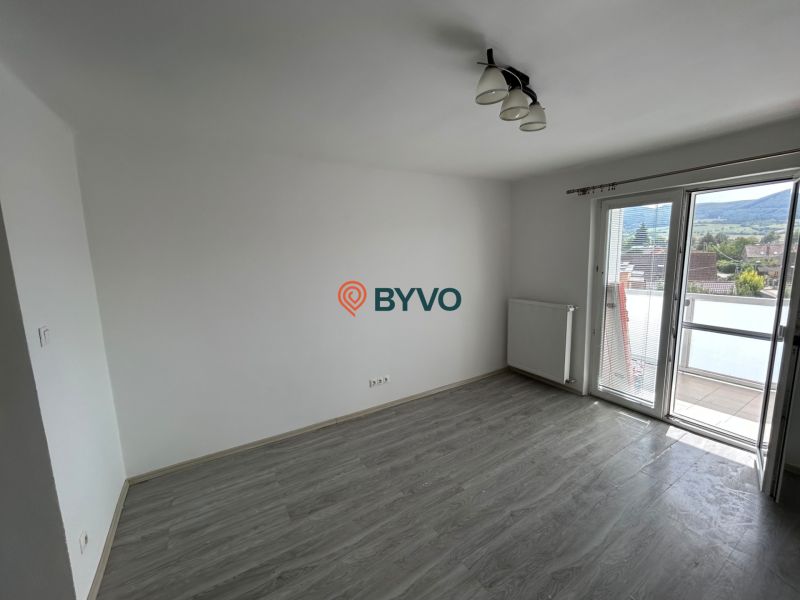 3-IZBOVÝ TEHLOVÝ BYT V DUBNICI N/V, BALKÓN, VLASTNÉ KÚRENIE A VÝBORNÉ  - Izba s podlahou s dreveným dekorom a balkónom v 3-izbovom byte.