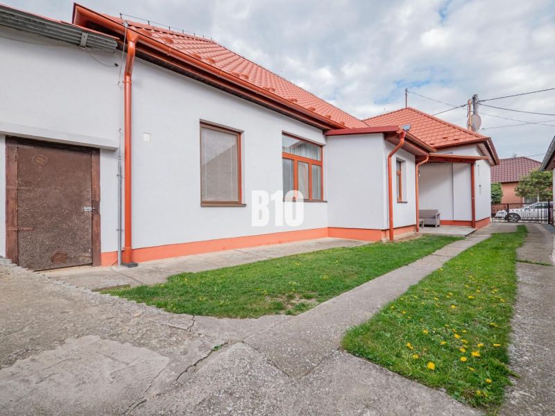 Prerobený dom, 981 m2 pozemok - Chrenová, Nitra (TOP lokalita) - Rodinný dom v Nitre s červenou strechou, dvorom a jednoduchou záhradnou úpravou.