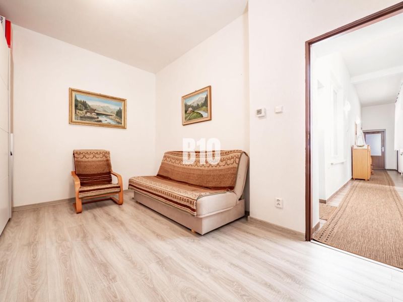 Prerobený dom, 981 m2 pozemok - Chrenová, Nitra (TOP lokalita) - Izba v rodinnom dome so sedačkou, kreslom a podlahou s dreveným dekorom.