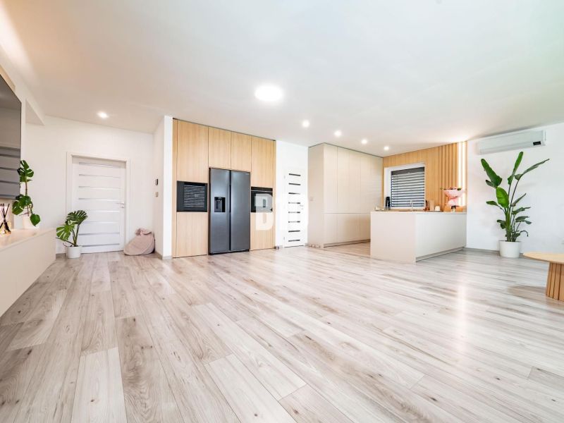 5 izb. bungalov s bazénom, garáž, RED OAK - Nitra, Lužianky - Interiér rodinného domu s podlahou s dreveným dekorom a modernou kuchyňou.