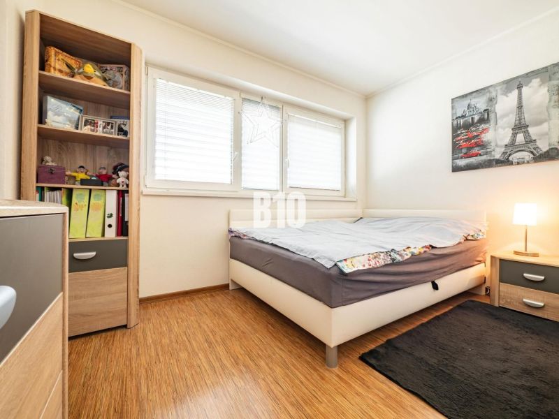 ZNÍŽENA CENA! 4 izb. rodinný dom, krásny pozemok  - Ivanka pri Nitre,  - Spálňa v rodinnom dome s podlahou s dreveným dekorom a poličkou plnou kníh a hračiek.