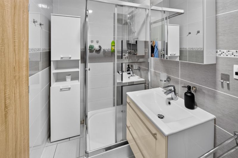 Predaj 2-izbový byt GREEN VILLAGE, loggia, parkovanie, Dunajská Lužná - Kúpeľňa so sprchovým kútom a bielym nábytkom v 2-izbovom byte.