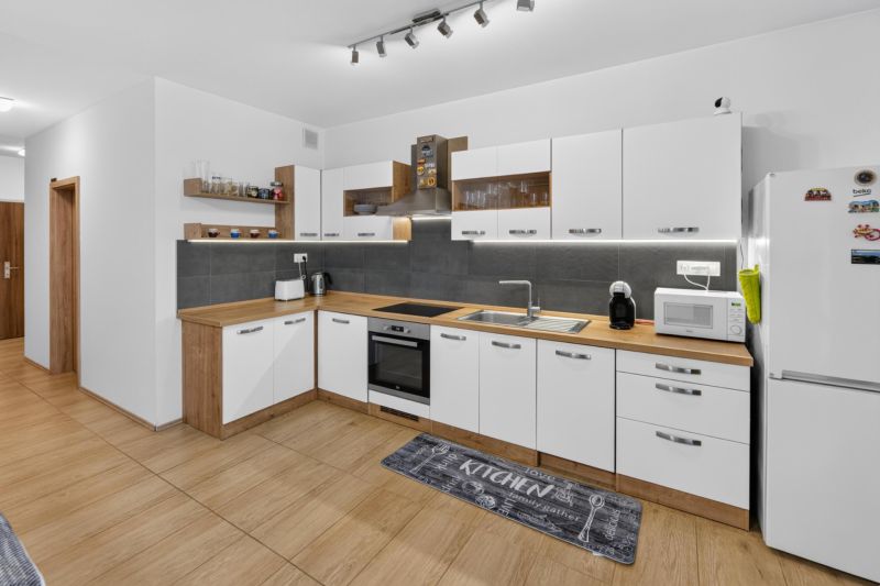 Predaj 2-izbový byt GREEN VILLAGE, loggia, parkovanie, Dunajská Lužná - Kuchyňa so svetlými skrinkami a podlahou s dreveným dekorom v 2-izbovom byte.
