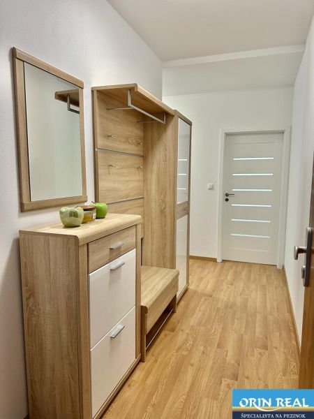 NOVÝ KRÁSNE ZARIADENÝ BYT s parkovacím miestom - Chodba v 2-izbovom byte s nábytkom a podlahou s dreveným dekorom.
