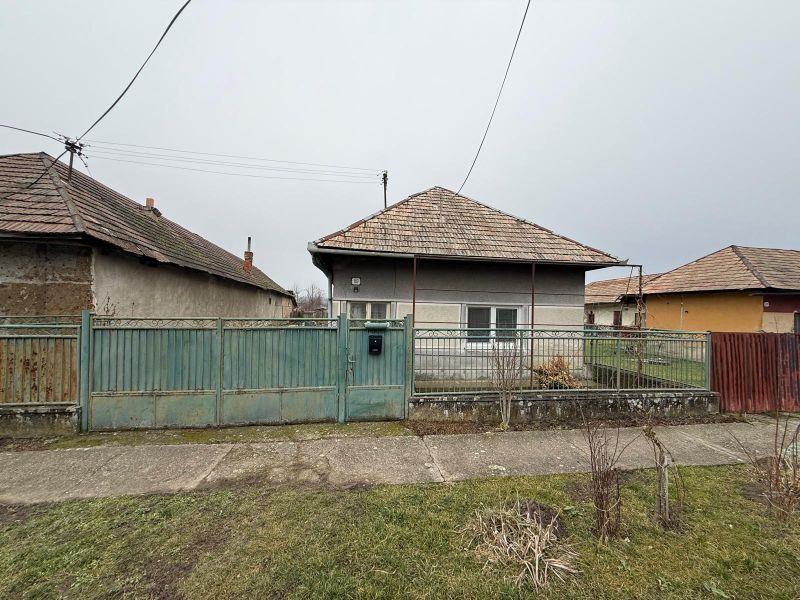 DOM NA PRENÁJOM, Obec Sikenica, okres Levice - Rodinný dom v Sikenici s plechovým plotom a šikmou strechou.
