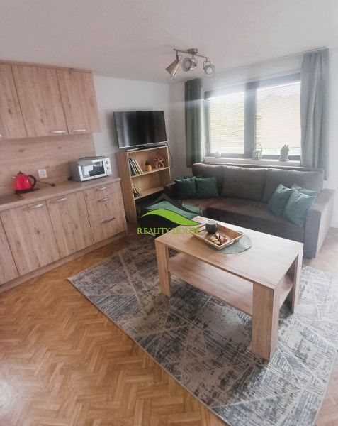 Trojpodlažná rekreačná chata  stredisko Kamenec - Zemplínska Šírava - Obývacia izba na chate s podlahou s dreveným dekorom, sedacou súpravou a stolíkom.