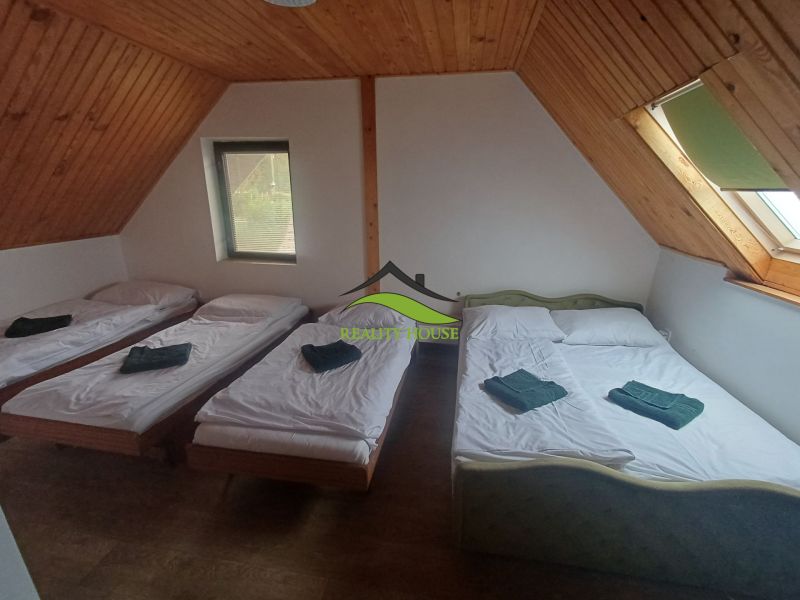 Trojpodlažná rekreačná chata  stredisko Kamenec - Zemplínska Šírava - Spálňa v chate s troma posteľami a podlahou s dreveným dekorom.