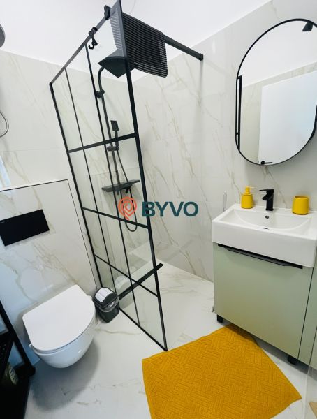 Na predaj 2.izbový byt v staršej novostavbe na začiatku Petržalky - Kúpeľňa v 2-izbovom byte so sprchovým kútom, závesným WC a oranžovým koberčekom.