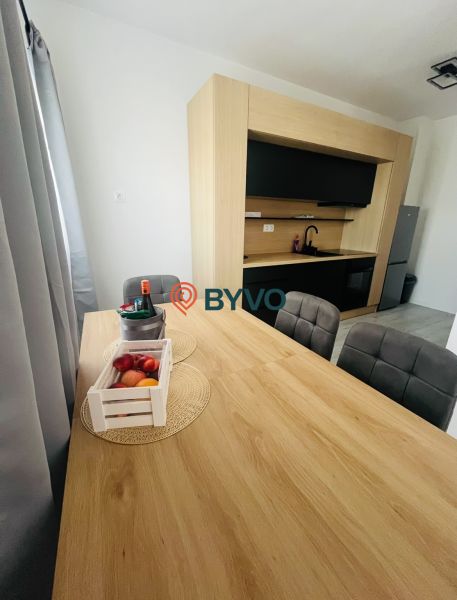 Na predaj 2.izbový byt v staršej novostavbe na začiatku Petržalky - Kuchyňa v 2-izbovom byte s jedálenským stolom a podlahou s dreveným dekorom.