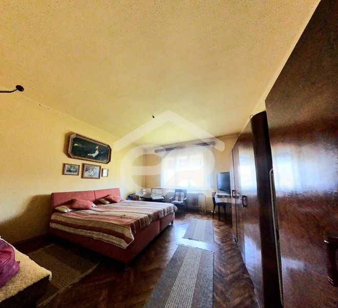Predaj 5-izbového domu s množstvom zelene! - Spálňa v rodinnom dome s podlahou s dreveným dekorom, posteľ, skrine, obrazy na stene.
