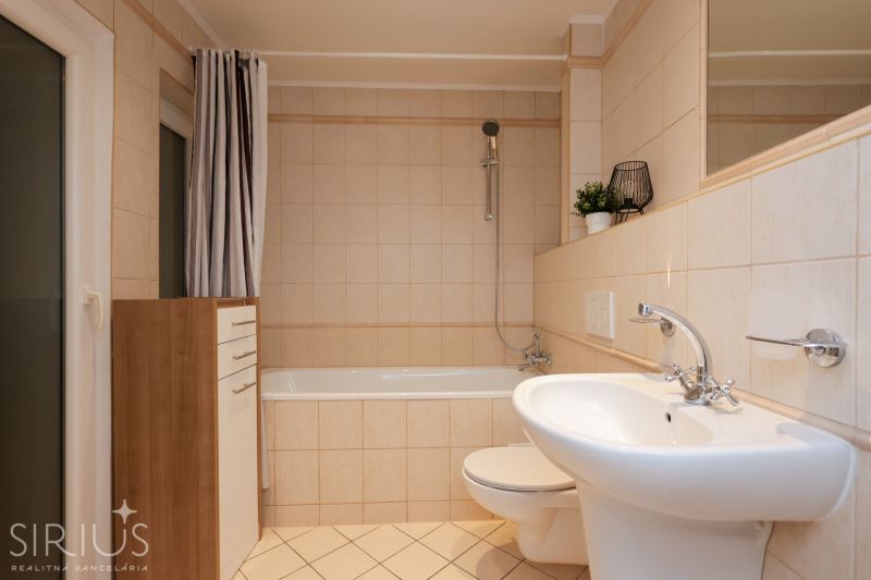 LAURINSKÁ, 2i byt, 68m² – REPREZENTATÍVNE bývanie v historickom CENTRE - Kúpeľňa s vaňou, umývadlom a skrinkou v 2-izbovom byte, béžový obklad.