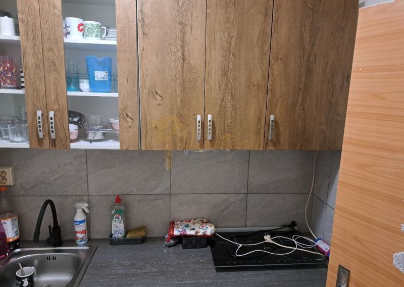 Garzónka, Rybničná ul., BA III - Vajnory - Kuchyňa s drevenými skrinkami, drezom a pracovnou doskou v garsónke.