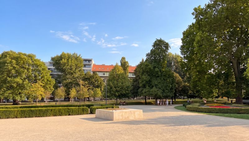I Exkluzívny 2-izbový byt v srdci Bratislavy, Staré Mesto - Záhrada s farebnými kvetmi, stromami a budovami v Bratislave - Starom Meste na Banskobystrickej.