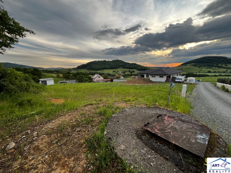 REZERVOVANÉ : Na predaj pozemok v obci Stožok – lokalita Pod Chvojnom - Pozemky - bývanie v Stožku so scenériou zelene a vidieckymi domami pri západe slnka.