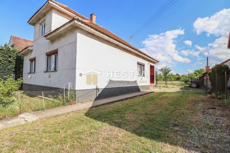 Rodinný dom Borský Mikuláš - Rodinný dom v Borskom Mikuláši s trávnatým pozemkom a modrou oblohou.