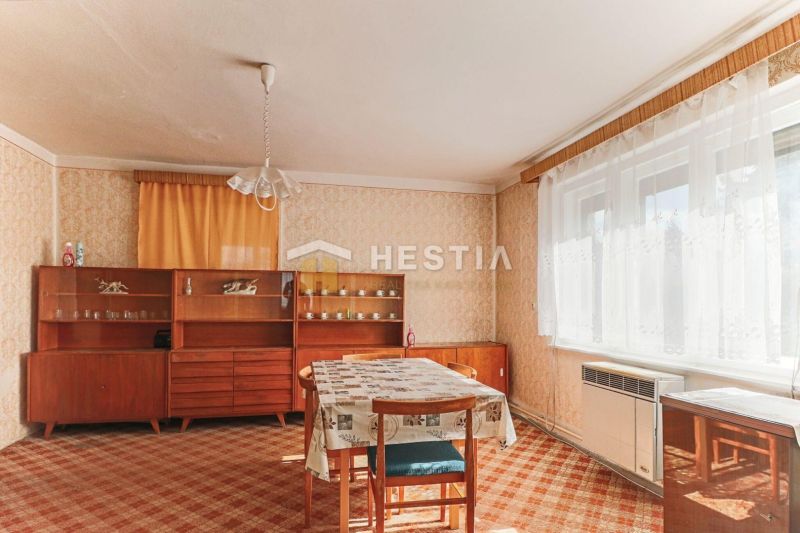 Rodinný dom Borský Mikuláš - Interiér rodinného domu s jedálenským stolom, starším nábytkom a kobercom.
