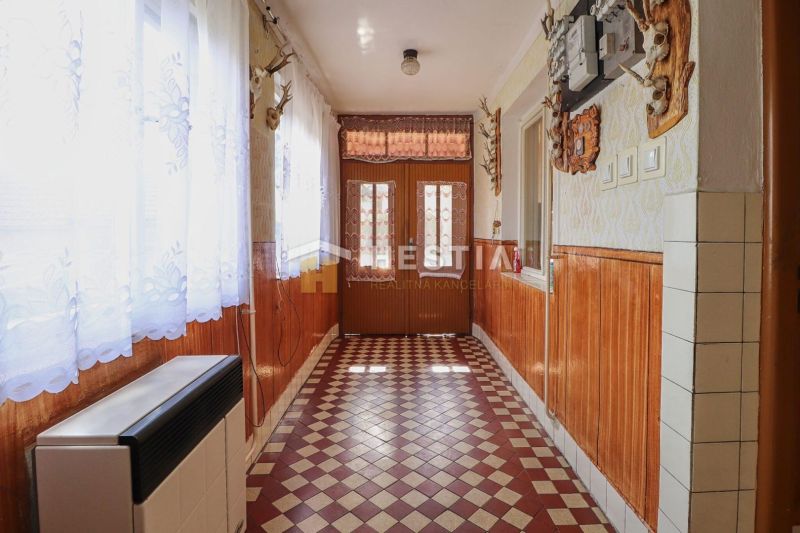 Rodinný dom Borský Mikuláš - Chodba v rodinnom dome s kachličkovanou podlahou a dreveným obkladom stien.