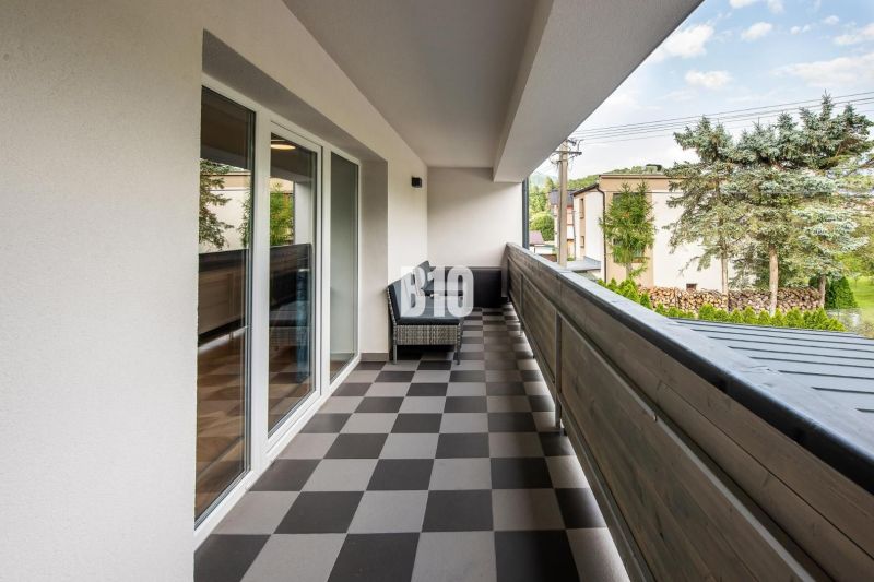 Investičný APARTMÁN v centre Terchovej - Balkón rekreačného apartmánu v Terchovej s dlažbou a pohľadom na okolie.