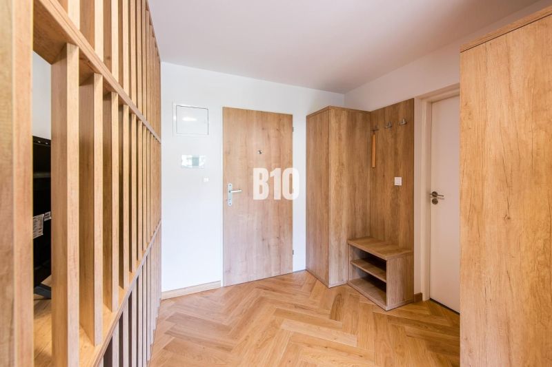Investičný APARTMÁN v centre Terchovej - Vstupná hala s dekorom dreva, dvere a podlaha s dreveným dekorom v Rekreačnom apartmáne.