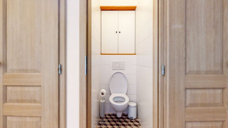 Priestranný 2i byt v obklopení zelene len pár krokov od OC Nivy | 53m² - Toaleta s bielymi obkladmi a vzorovanou podlahou v 2-izbovom byte.