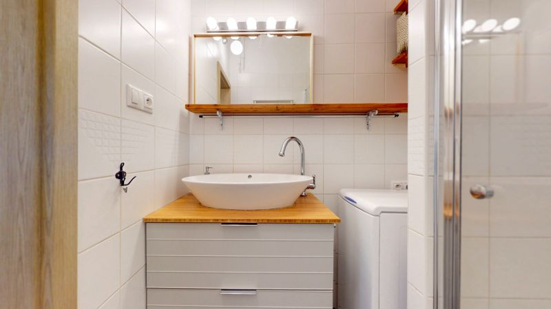Priestranný 2i byt v obklopení zelene len pár krokov od OC Nivy | 53m² - Kúpeľňa v 2-izbovom byte s umývadlom na drevenej doske a práčkou.