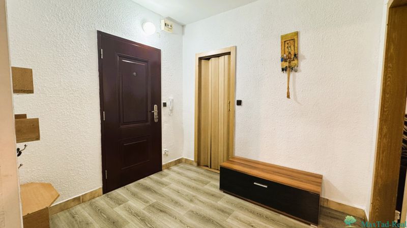 94,66 m², štyri izby a nikto nad hlavou. A Komenského má svoje výhody! - Interiér 4-izbového bytu s bielymi stenami, podlahou s dreveným dekorom a tmavými dverami.