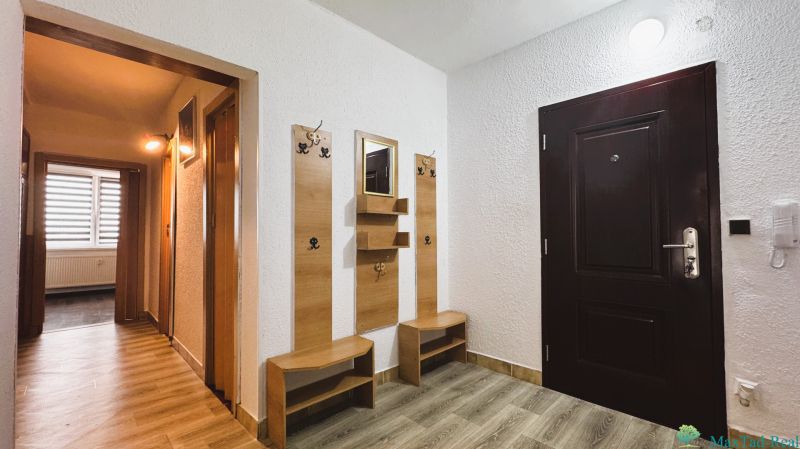 94,66 m², štyri izby a nikto nad hlavou. A Komenského má svoje výhody! - Vstupná chodba so zrkadlom a vešiakom, 4-izbový byt s podlahou s dreveným dekorom.
