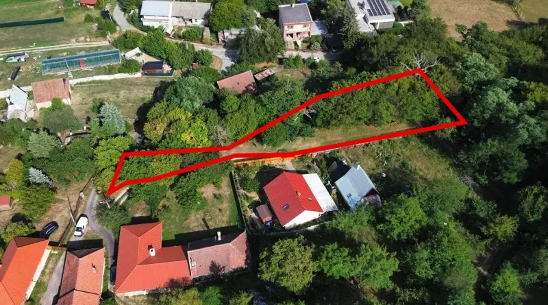 Kolačno – 90 m2 INVESTIČNÝ pozemok v obci - Predaj - Letecký pohľad na pozemok v záhradách v Kolačne, obklopený zeleňou a domami.