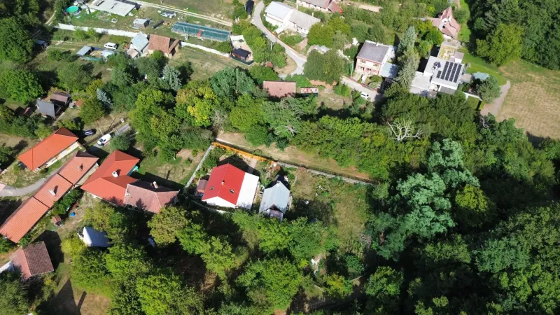 Kolačno – 90 m2 INVESTIČNÝ pozemok v obci - Predaj - Letecký pohľad na Záhrady v Kolačne s rozptýlenými domami a bujnou zeleňou.
