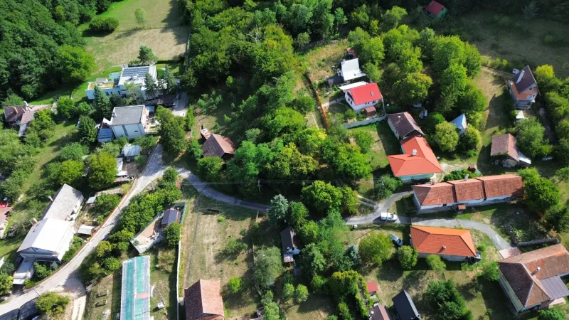 Kolačno – 90 m2 INVESTIČNÝ pozemok v obci - Predaj - Letecký pohľad na malebné Záhrady v Kolačne s roztrúsenými domami a zeleňou.