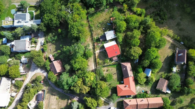 Kolačno – 90 m2 INVESTIČNÝ pozemok v obci - Predaj - Letecký pohľad na záhrady a domy v Kolačne, obklopené hustou zeleňou.