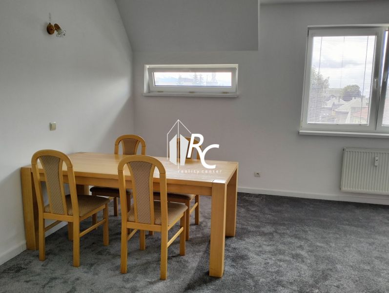 Prenájom dvoch 2-izbových bytov vedľa seba, Martin - centrum - Stôl so štyrmi stoličkami v 2-izbovom byte, sivý koberec, dve okná.
