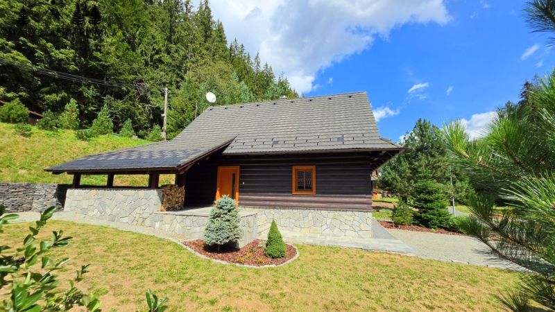 Útulná 4i chalupa pri potoku – Jarabá, Nízke Tatry - Chata v Jarabej obklopená lesom a upravenou záhradou pod modrou oblohou.
