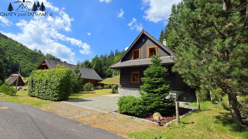 Útulná 4i chalupa pri potoku – Jarabá, Nízke Tatry - Chata v Jarabej obklopená stromami a modrou oblohou v horskej krajine.