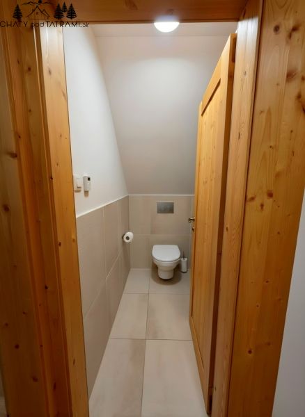 Útulná 4i chalupa pri potoku – Jarabá, Nízke Tatry - Interiér chaty s WC, svetlé dlaždice a drevené obloženie stien dverí.