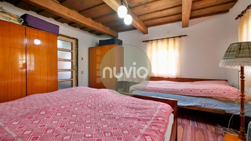 Rezervované - Tradičná drevenica s potenciálom v Žabokrekoch - Spálňa v rodinnom dome s dreveným stropom, skrinkami a svietidlom.