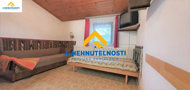 Výborná investičná príležitosť na podnikanie, či bývanie. - Izba v rodinnom dome s pohovkou, posteľou a televízorom na stene.