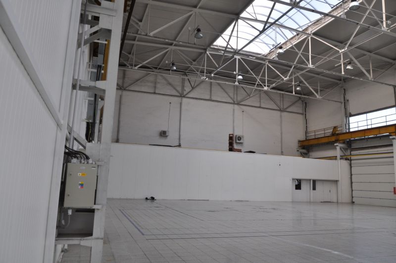 Priemyselná hala 2 500 m²  SKLADOVANIE, VÝROBA, LOGISTIKA - Interiér výrobných priestorov s vysokým stropom, podlahou a prirodzeným svetlom zo strechy.