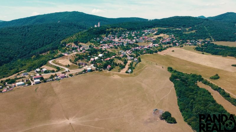 POZEMOK NA VÝSTAVBU PODHRADIE - Letecký pohľad na Podhradie s rodinnými domami a prírodou. Pozemky - bývanie.