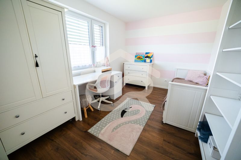 Na predaj 5i rodinný dom, novostavba, Vráble, pozemok 1200m2 - Detská izba s bielym nábytkom a podlahou s dreveným dekorom v rodinnom dome.