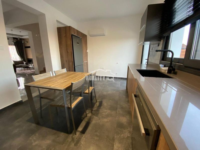 MODERNÁ VILA 3+1 S VÝHĽADOM NA MORE A HORY | YENİ BOĞAZİÇİ, - Kuchyňa rodinného domu zobrazuje jedálenský stôl, drevené prvky a tmavú podlahu.
