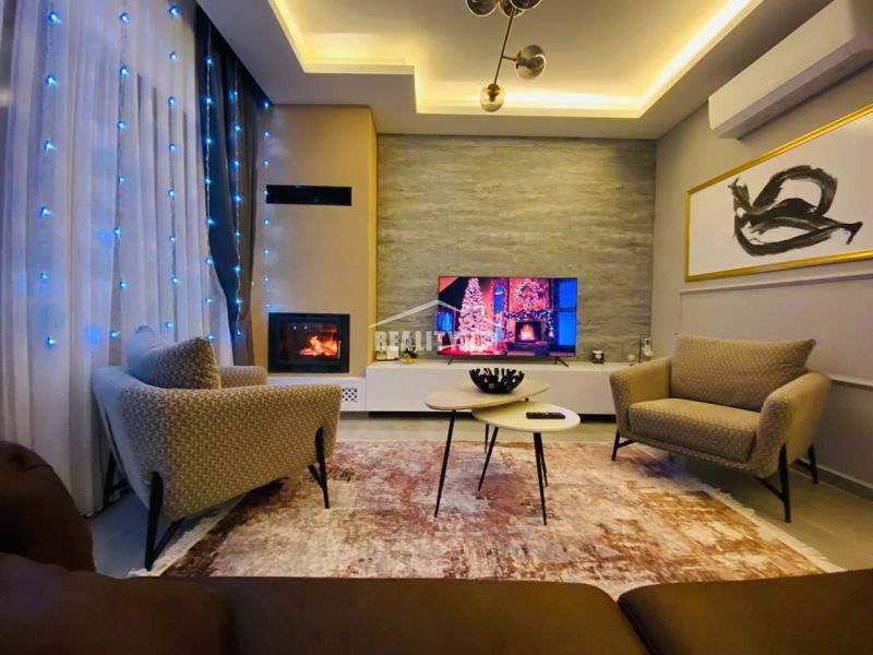MODERNÁ VILA 3+1 S VÝHĽADOM NA MORE A HORY | YENİ BOĞAZİÇİ, - Obývacia izba s pohodlnými kreslami, dekoratívnymi svetlami a krbom v rodinnom dome.