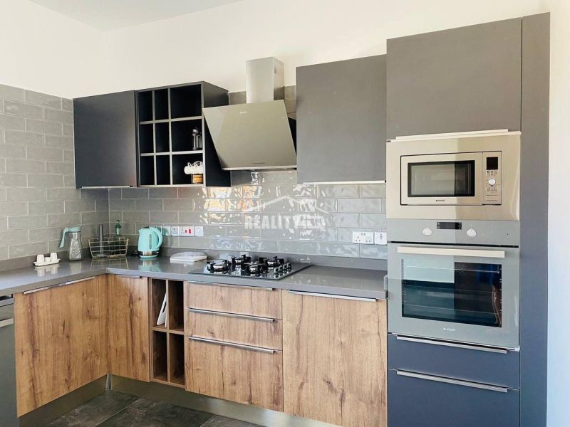 MODERNÁ VILA 3+1 S VÝHĽADOM NA MORE A HORY | YENİ BOĞAZİÇİ, - Kuchyňa s podlahou s dreveným dekorom a šedými skrinkami v rodinnom dome.