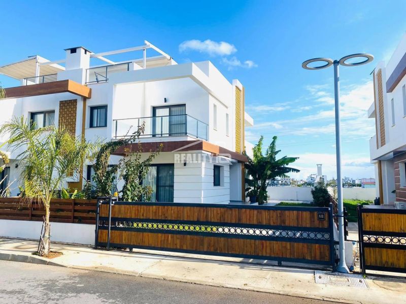 MODERNÁ VILA 3+1 S VÝHĽADOM NA MORE A HORY | YENİ BOĞAZİÇİ, - Rodinný dom v Yeni Boğaziçi so záhradou a drevenými prvkami na fasáde.