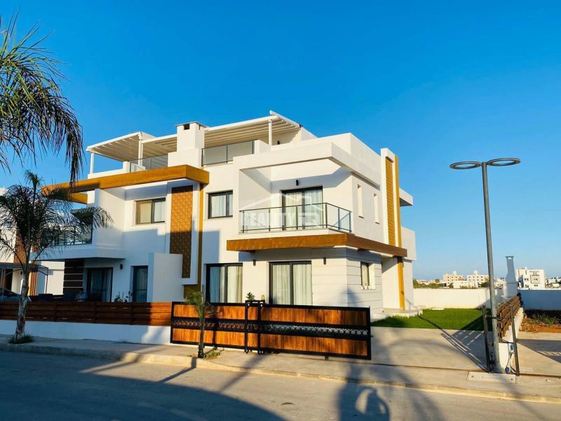 MODERNÁ VILA 3+1 S VÝHĽADOM NA MORE A HORY | YENİ BOĞAZİÇİ, - Rodinný dom v Yeni Boğaziçi s bielou fasádou, drevenými prvkami a palmami na pozemku.