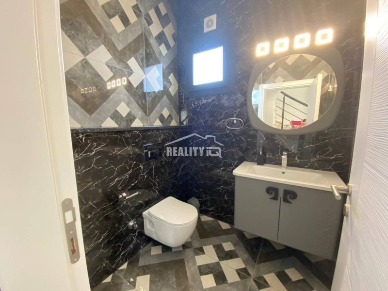 MODERNÁ VILA 3+1 S VÝHĽADOM NA MORE A HORY | YENİ BOĞAZİÇİ, - Kúpeľňa v rodinnom dome s tmavým obložením a geometrickými vzormi na stenách.