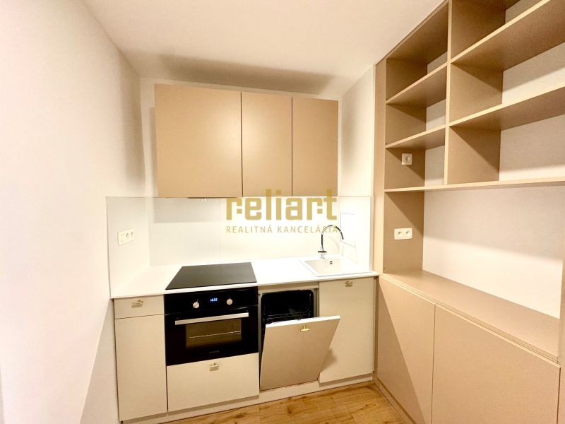 Na predaj úplne nový 1i byt od architekta v tichej časti Dúbravky - Kuchynská linka v 1-izbovom byte s podlahou s dreveným dekorom, svetlé skrinky.